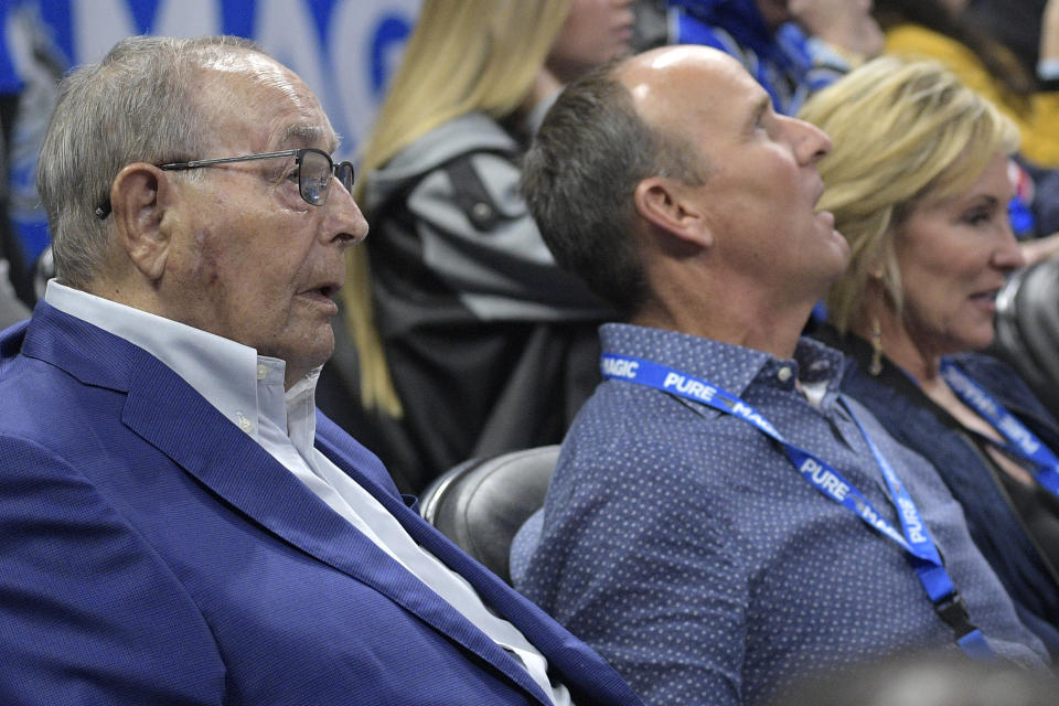Rich DeVos (left) and his son, Doug, sit courtside at an Orlando Magic game in January. (AP)