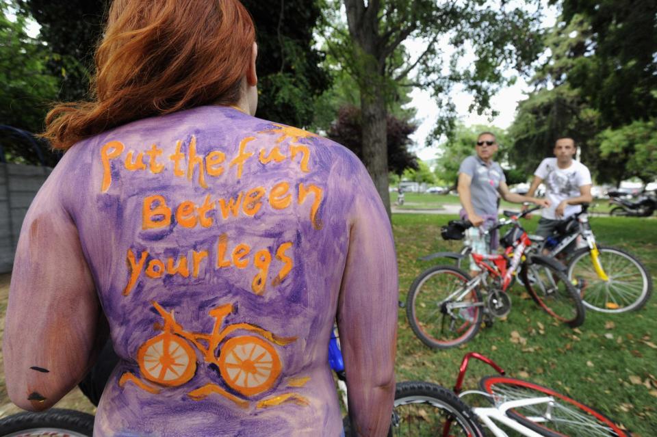 Cyclists look at a naked cyclist taking part in World Naked Bike Ride in Thessaloniki, northern Greece