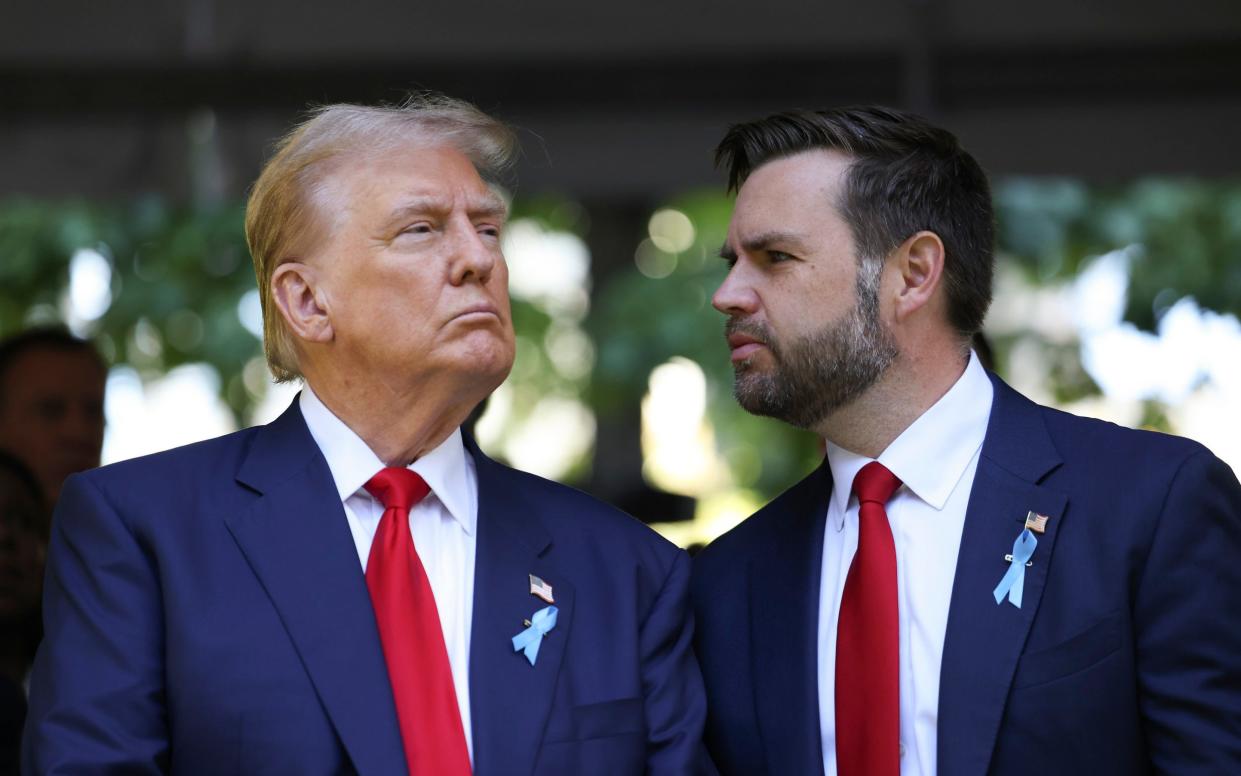 Donald Trump confers with JD Vance, his running mate, at a 9/11 memorial event in New York