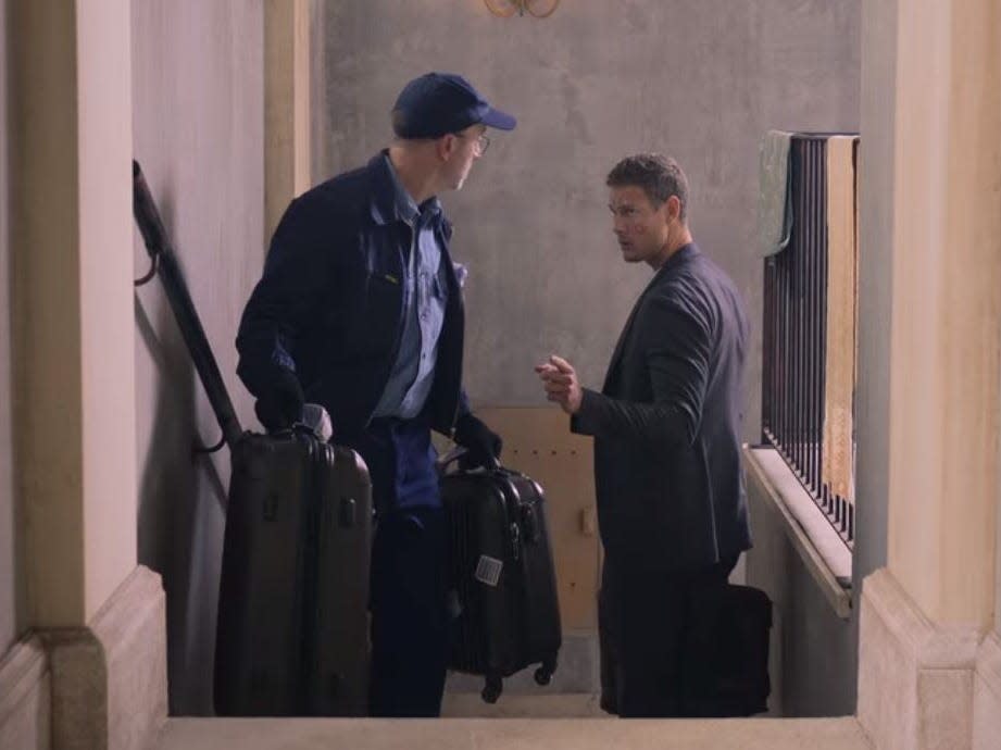 charlie handing julie's suitcases to a donation collector in love in the villa