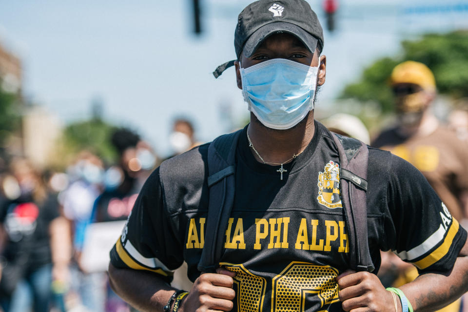 A member of Alpha Phi Alpha stands in a crowd during a Mothers' March on June 14, 2020, in Minneapolis. 