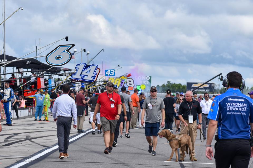 Fans walk along the grid at Pocono Raceway prior to the Pocono Organics CBD 325 Cup Series race on Saturday, June 26, 2021. Fans joined drivers and crew members on the grid for introductions before the race for the first time in two years.