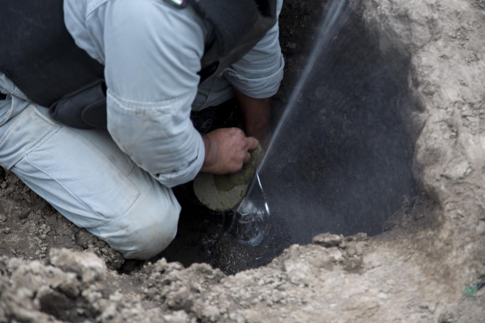 Un técnico de seguridad de Pemex inspecciona una toma ilegal de petróleo en San Bartolome Hueyapan, Tepeaca, México. (AP Photo/Eduardo Verdugo)