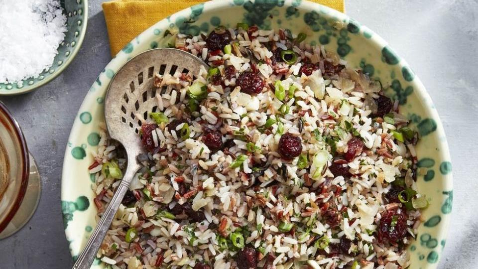 wild rice and cider cranberry pilaf in a bowl with a serving spoon