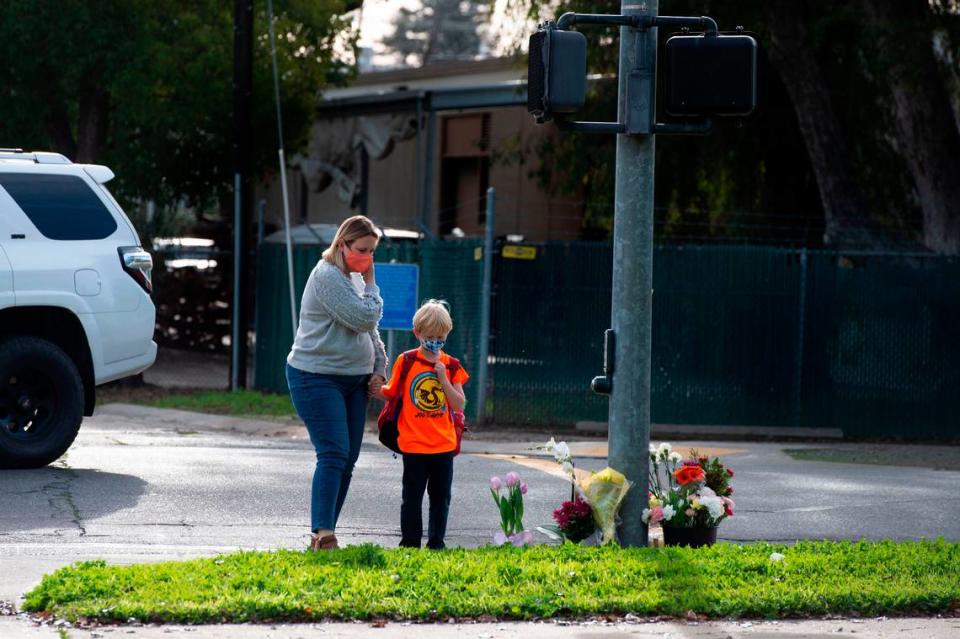 Alicia Hanley and her son Nolan, 6, a first grader at Phoebe Hearst Elementary School, put out flowers on Friday, Jan. 14, 2022, at the corner of Folsom Boulevard and 60th Street, where a parent pedestrian was tragically killed by a car involved in a car accident Thursday, while walking near the school to pickup her child.