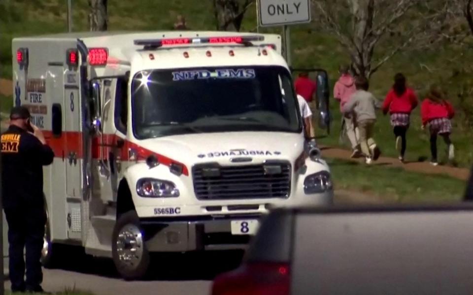 Children run past an ambulance after the shooting - WKRN/NEWSNATION