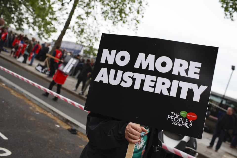 A woman carries an anti-austerity placard as demonstrators calling for fairer pay and rights for workers, as well as against public service cuts and workplace discrimination, gather on Victoria Embankment ahead of the 'New Deal for Working People' march organised by the Trades Union Congress (TUC) in London, England, on May 12, 2018. (Photo by David Cliff/NurPhoto via Getty Images)