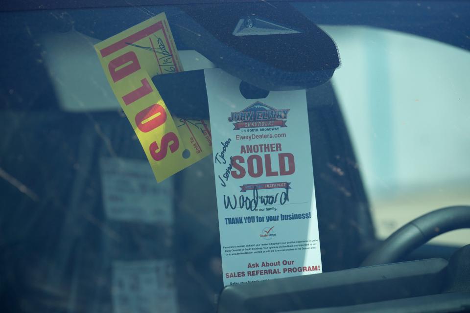 A sold tag hangs from the inside rear-view mirror of a 2023 Colorado pickup truck at a Chevrolet dealership on June 18, 2023, in Englewood, Colo.