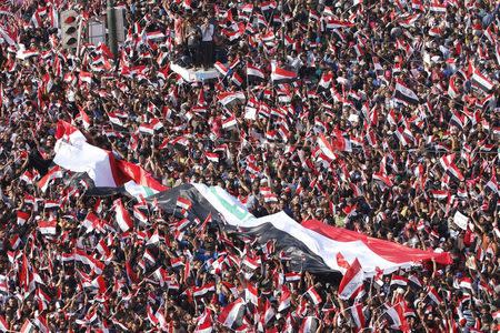 Supporters of prominent Iraqi Shi'ite cleric Moqtada al-Sadr display a huge Iraqi flag during a protest against government corruption at Tahrir Square in Baghdad, Iraq March 11, 2016. REUTERS/Ahmed Saad