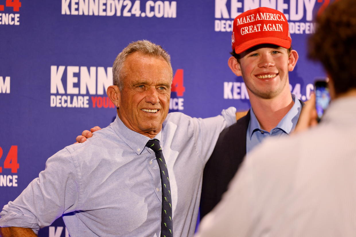 Independent presidential candidate Robert F. Kennedy Jr. poses for a photograph with a member of the audience wearing a Make America Great Again cap.