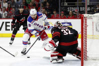 New York Rangers' Ryan Strome (16) drives the puck toward Carolina Hurricanes goaltender Antti Raanta (32) with Hurricanes' Brett Pesce (22) watching during the first period of Game 1 of an NHL hockey Stanley Cup second-round playoff series in Raleigh, N.C., Wednesday, May 18, 2022. (AP Photo/Karl B DeBlaker)