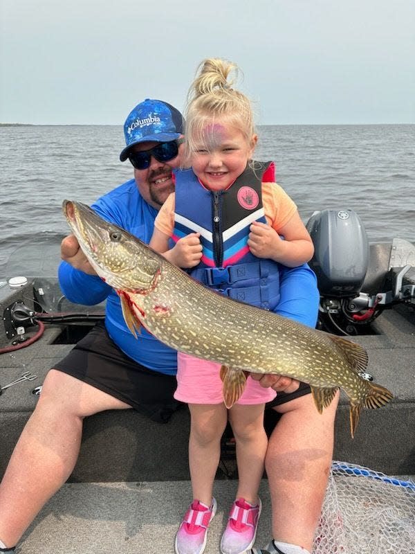 Tim Wollak and his daughter, Henley, pose with a game fish they caught on Lake Michigan. Their shared hobby led to their discovery of a long-lost shipwrecked boat built before the Civil War.