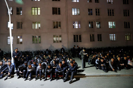 People sit by the road near the main Kim Il Sung square in central Pyongyang, North Korea April 11, 2017. REUTERS/Damir Sagolj