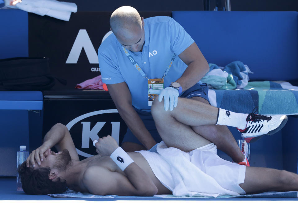 Portugal's Joao Sousa receives treatment from a trainer during his third round match against Japan's Kei Nishikori at the Australian Open tennis championships in Melbourne, Australia, Saturday, Jan. 19, 2019. (AP Photo/Kin Cheung)