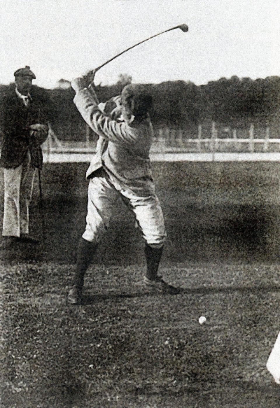 a black and white photo of a man holding a golf club mid-swing at the 1900 olympics