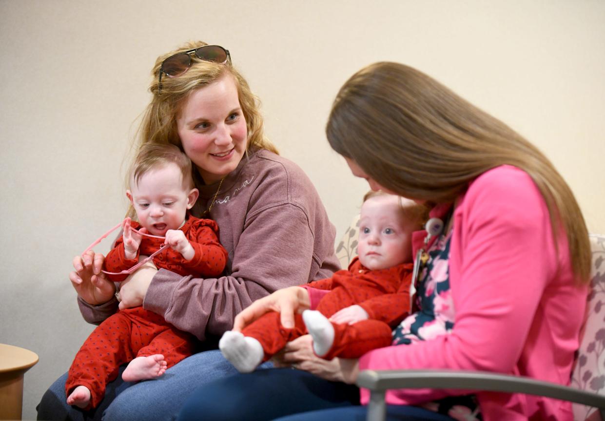 Haley Hake, left, and her twin daughters, Anna and Ella, visit Dr. Arielle Bokisa, a neonatologist at Akron Children's Hospital neonatal intensive care unit at Aultman Hospital in Canton.