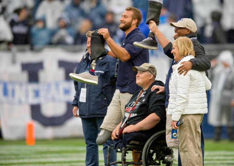 Penn State students and wounded warriors Max Rohn and Ed Bonfiglio lift their prosthetic legs to the crowd as they are honored during the Saturday, October 3, 2015 Penn State football game against Army at Beaver Stadium.