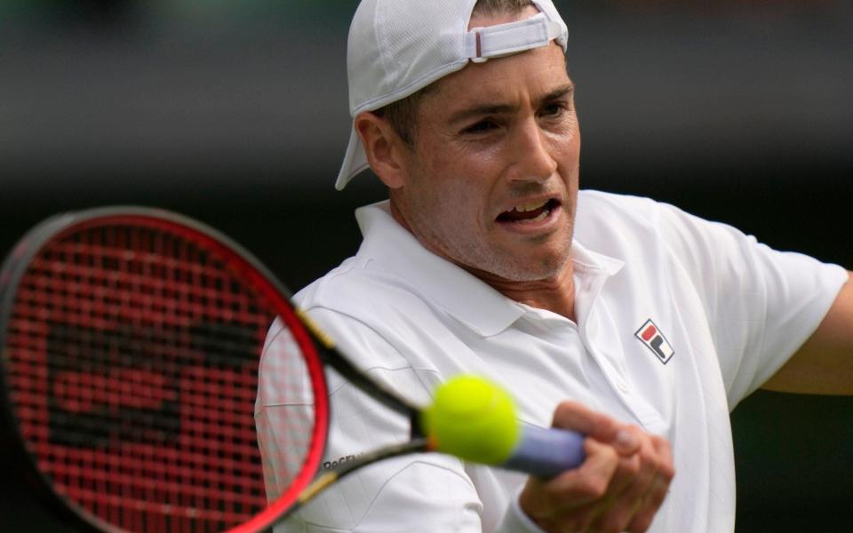 John Isner of the US returns the ball to Britain's Andy Murray during their singles tennis match on day three - AP Photo/Alastair Grant