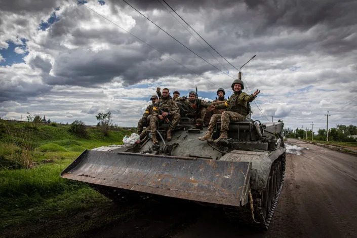 Ukrainian soldiers sitting on an armored vehicle near the the Russian front line in Donetsk in May 2022. <a href=