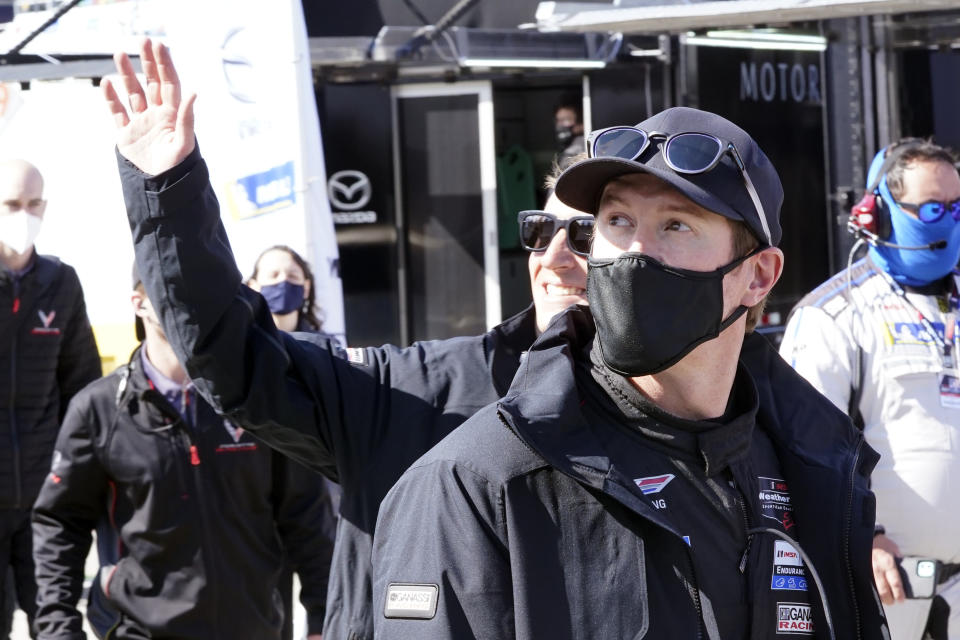 Scott Dixon, right, of New Zealand and Reneger van der Zande, left, acknowledge fans in the Fan Zone as they walk back to their garage after a practice session for the Rolex 24 hour race at Daytona International Speedway, Friday, Jan. 29, 2021, in Daytona Beach, Fla. (AP Photo/John Raoux)