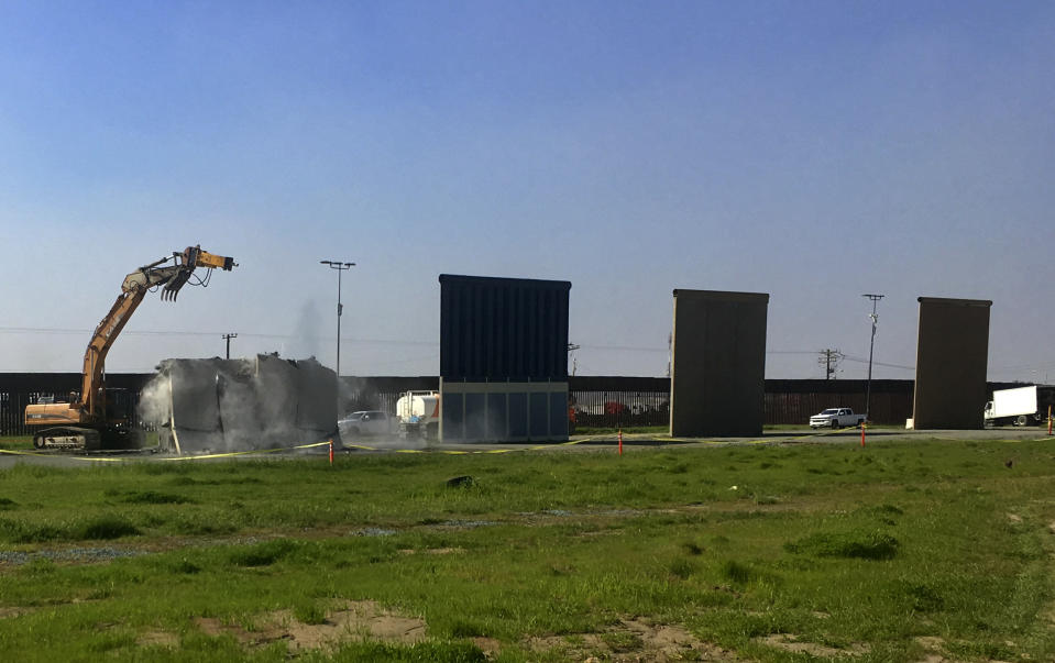 Work crews begin to demolish border wall prototypes in San Diego on Wednesday, Feb. 27, 2019. The Trump administration on Wednesday began to demolish eight prototypes of the president's prized border wall that the government built near San Diego one year ago. (AP Photo/Elliot Spagat)