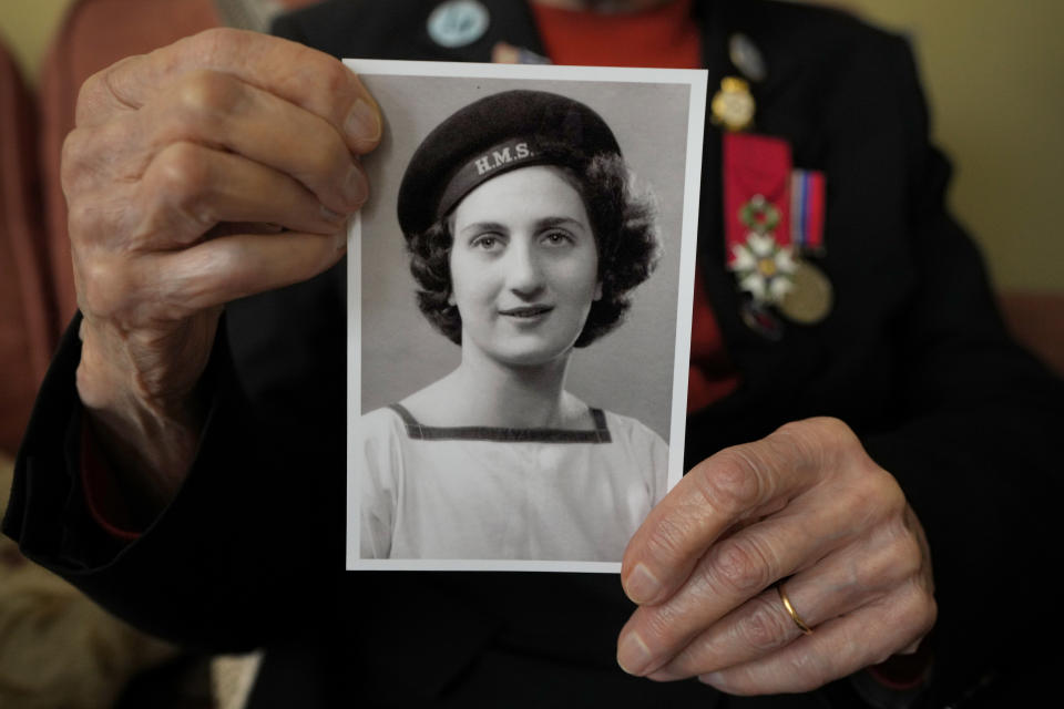 Marie Scott who was a serving Wren and switchboard operator at the time of D-Day, holds up a photograph of herself in 1944, at her home in London, Thursday, April 25, 2024. D-Day, took place on June 6, 1944, the invasion of the beaches at Normandy in France by Alied forces during World War II. (AP Photo/Kirsty Wigglesworth)