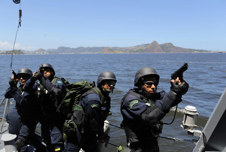 CORRECTS WEDNESDAY TO THURSDAY - Brazilian Marines practice raiding a ship during a military exercise in Guanabara Bay, in Rio de Janeiro, Brazil, Thursday, Feb. 20 2014. Brazil’s Navy said that the operations being carried out this week in preparation for the 2014 FIFA World Cup are the largest exercises in its history. FIFA director of security Ralf Mutschke has said that FIFA is satisfied with the level of security that will be provided by Brazilian authorities, and guarantees that football's governing body "is highly committed to ensuring the safety and security for fans, players and any other stakeholder involved in our event." (AP Photo/Leo Correa)