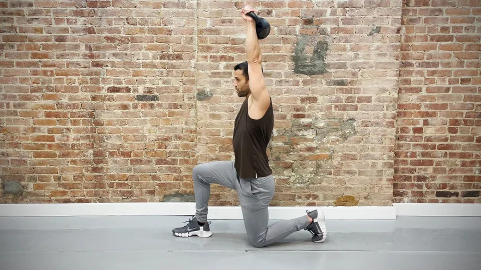 tamir practicing the halfkneeling singlearm overhead press exercise