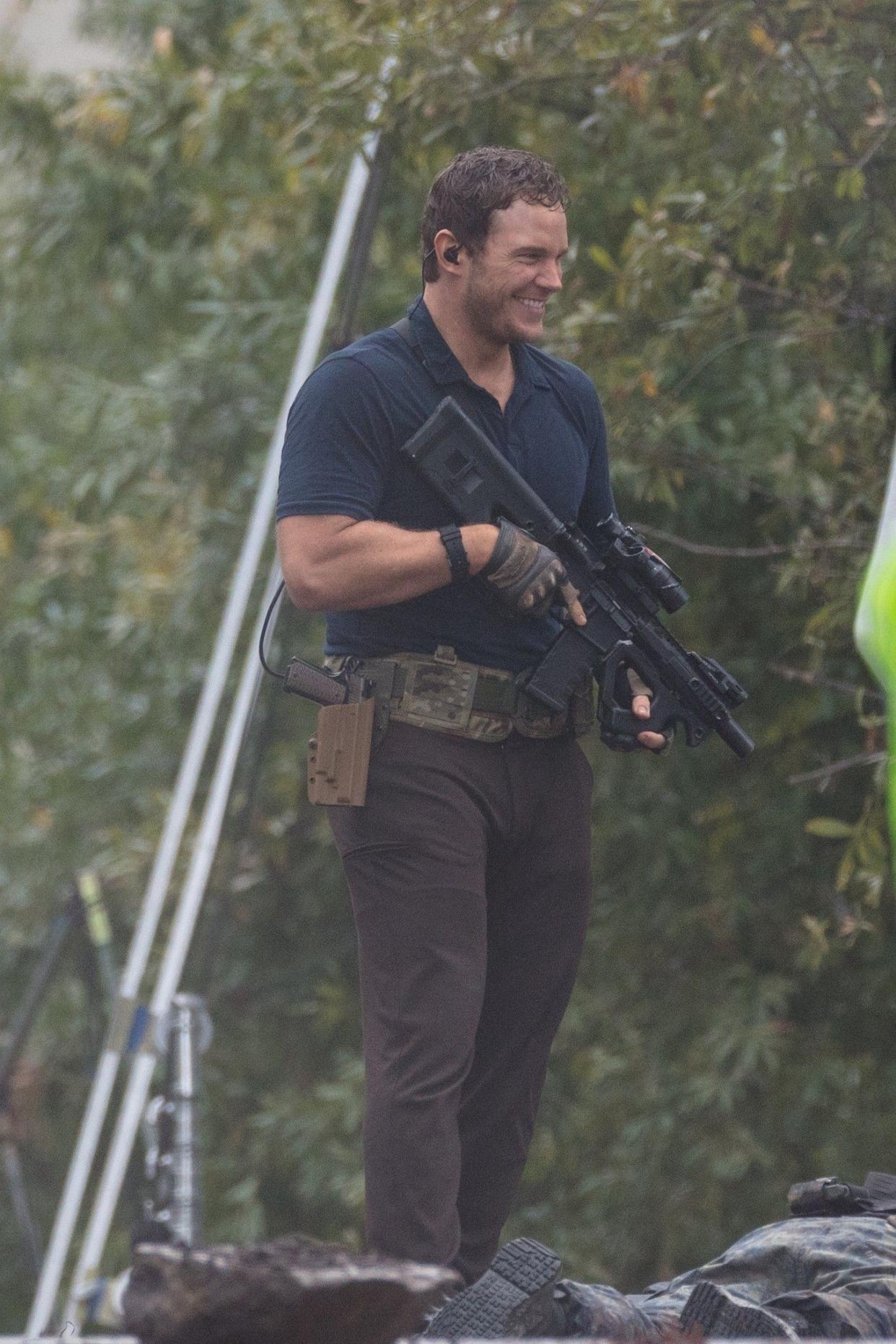 Chris Pratt gives a smile while holding a rifle on the set of his upcoming film "Ghost Draft" on Oct. 26, 2019. This is the first project Pratt has worked on since his wedding to Katherine Schwarzenegger in June.