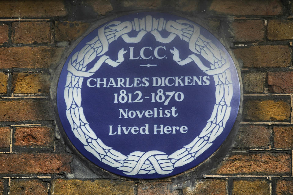 FILE - In this Dec. 5, 2012 file photo, a blue plaque is seen on the exterior of Charles Dickens' home, part of the Charles Dickens Museum in London. For years, the four-story brick row house where the author lived with his young family was a dusty and slightly neglected museum, a mecca for Dickens scholars but overlooked by most visitors to London. Now, after a 3 million pound ($4.8 million) makeover, it has been restored to bring the writer's world to life. Its director says it aims to look "as if Dickens had just stepped out." (AP Photo/Sang Tan, File)