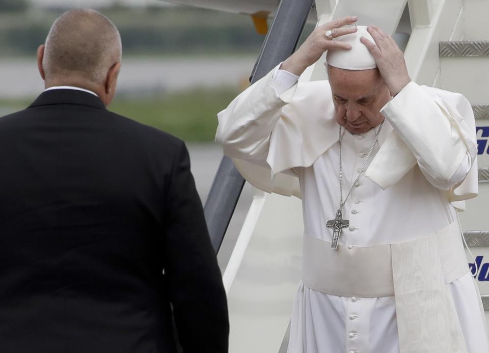 Pope Francis adjusts his skull cap in front of Prime Minister Boyko Borisov upon his arrival in Sofia, Bulgaria, Sunday, May 5, 2019. Pope Francis is visiting Bulgaria, the European Union's poorest country and one that taken a hard line against migrants, a stance that conflicts with the pontiff's view that reaching out to vulnerable people is a moral imperative. (AP Photo/Alessandra Tarantino)