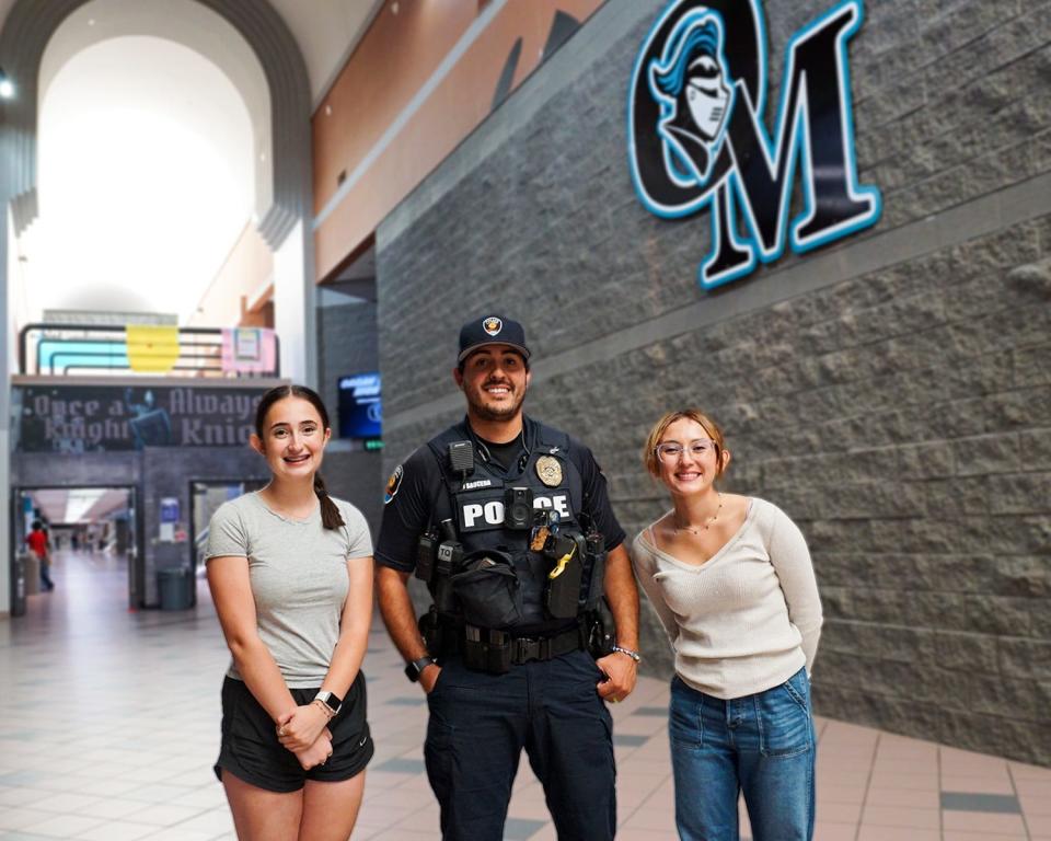 Madelyn Danner, left, and Jeorgina Cardenas, right, pose for a photo with Organ Mountain High School resource officer Jason Sauceda, center, on Sept. 15, 2023.