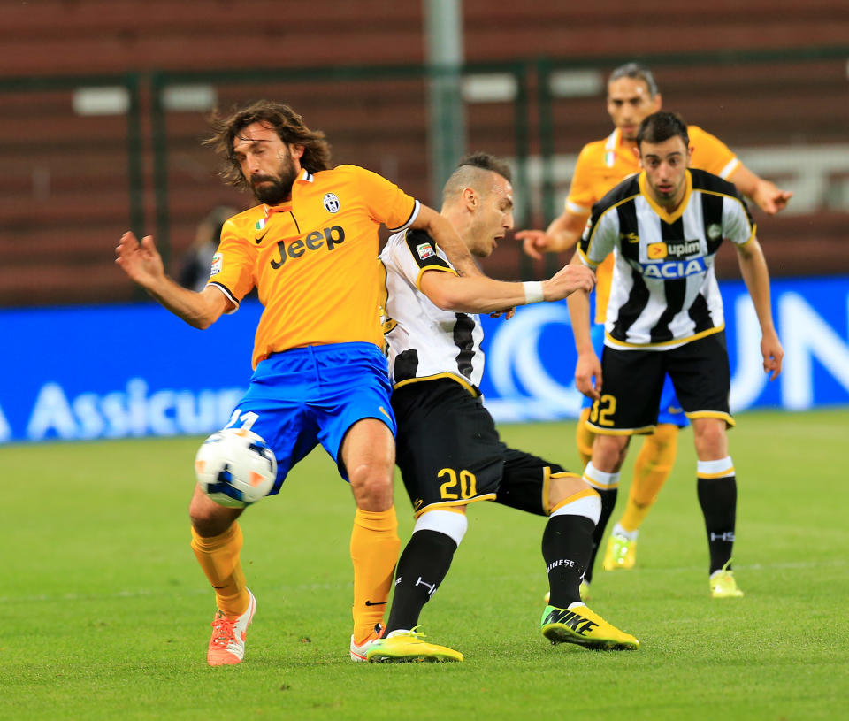 Juventus's Andrea Pirlo, left, and Udinese's Hassan Yebda, fight for the ball during the Serie A soccer match between Udinese and Juventus at the Friuli Stadium in Udine, Italy, Monday, April 14 2014. (AP Photo/Paolo Giovannini)