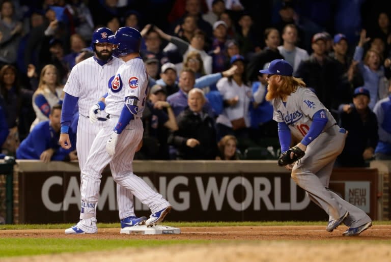 Justin Turner (R) of the Los Angeles Dodgers attempts to tag Alex Avila and Albert Almora Jr. of the Chicago Cubs in the ninth inning during game three of the National League Championship Series, at Wrigley Field in Chicago, on October 17, 2017