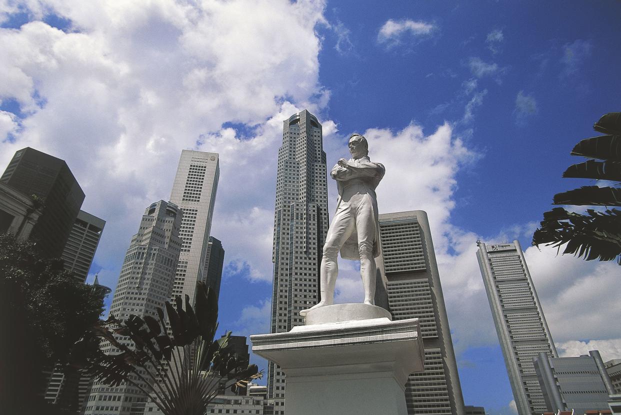 Statue of Thomas Stamford Raffles (1781-1826), founder of the city, with the Central Business District in the background, Singapore.