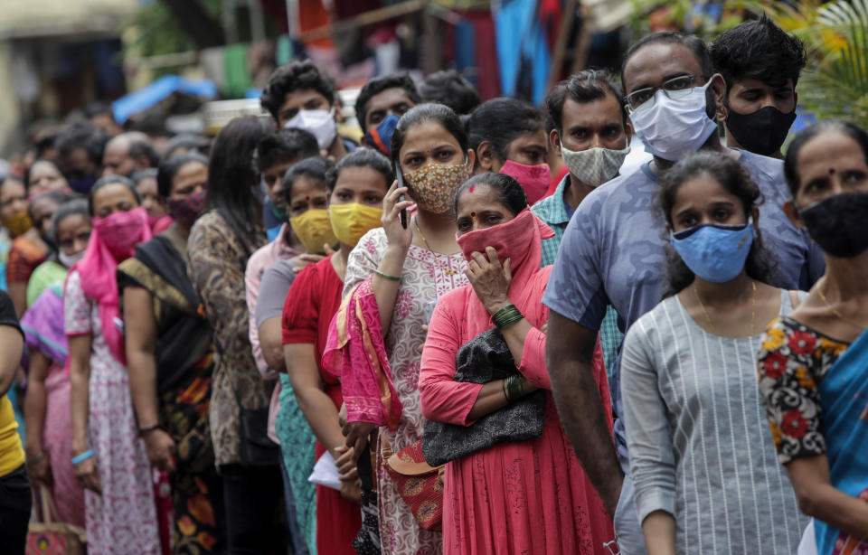 People line up to get inoculated against the coronavirus at a vaccination camp organized by the Reliance Foundation and Municipal Corporation of Greater Mumbai in Mumbai, India, Monday, Aug. 2, 2021. (AP Photo/Rajanish Kakade)