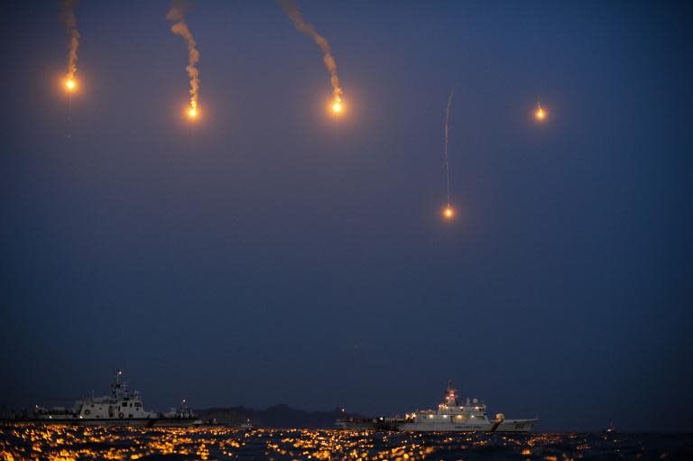 Coastguard boats and search and rescue teams take part in recovery operations at night at the site of the 'Sewol' ferry, off the coast of the South Korean island of Jindo on April 24, 2014