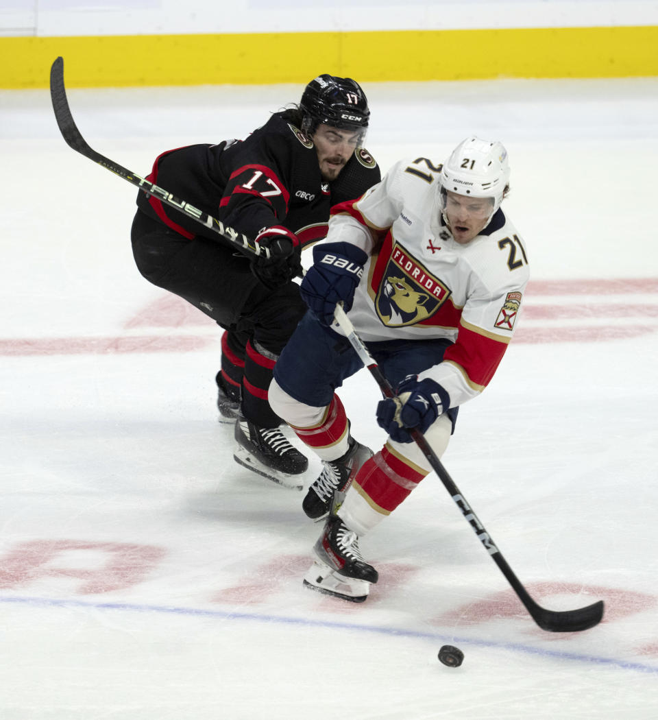 Ottawa Senators center Zack MacEwen (17) tries to knock Florida Panthers center Nick Cousins (21) off the puck during second-period NHL hockey game action in Ottawa, Ontario, Monday, Nov. 27, 2023. (Adrian Wyld/The Canadian Press via AP)