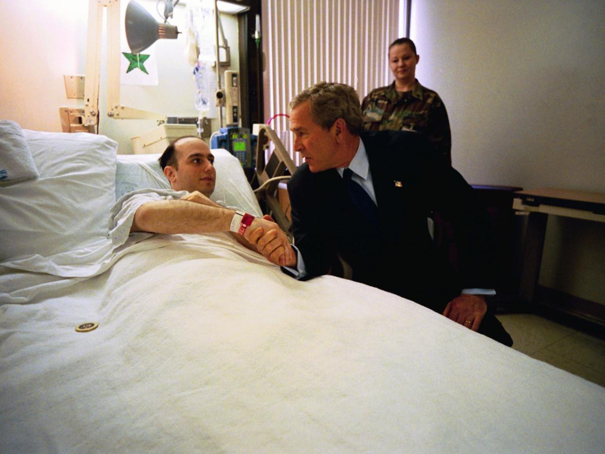 President George W. Bush shakes hands with U.S. Army Specialist Salvatore Cavallaro while visiting Walter Reed Army Medical Center: Eric Draper/White House via Getty Images