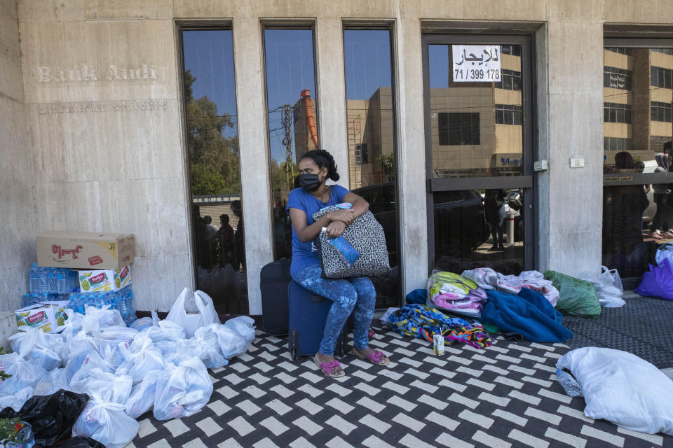 An Ethiopian domestic worker waits in front of the Ethiopian consulate after she and others were abandoned by their Lebanese employers, in Hazmieh, east of Beirut, Lebanon, Thursday, June 4, 2020. On Wednesday night, dozens of Ethiopian workers abandoned by their employers were transported to a hotel by the Labor Ministry where they could stay until they can be flown out of the country, after chaotic scenes outside the consulate. (AP Photo/Hassan Ammar)