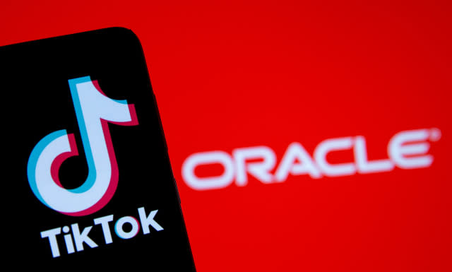 A smartphone with the Tik Tok logo is seen in front of a displayed Oracle logo in this illustration taken, Septemeber 14, 2020. REUTERS/Dado Ruvic/Illustration - RC27YI9D74SH