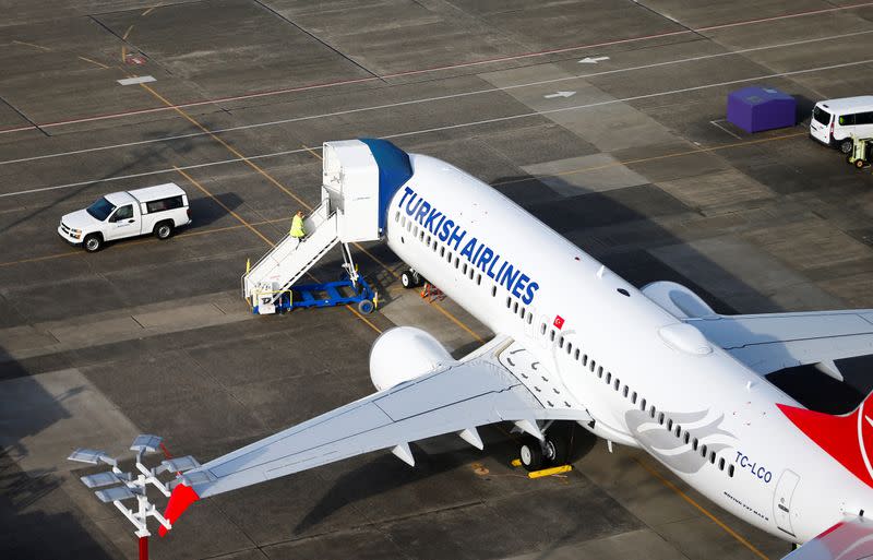 An aerial photo shows a worker climbing up to a Turkish Airlines Boeing 737 MAX airplane grounded at Boeing Field in Seattl