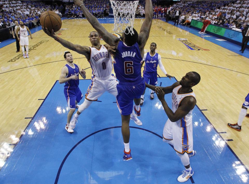 Oklahoma City Thunder guard Russell Westbrook (0) shoots in front of Los Angeles Clippers center DeAndre Jordan (6) in the second quarter of Game 2 of the Western Conference semifinal NBA basketball playoff series in Oklahoma City, Wednesday, May 7, 2014. Thunder forward Serge Ibaka (9) is at right. (AP Photo/Sue Ogrocki)