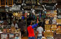 <p>A boy cleans the religious pictures for sale at a shop during Ramadan outside the shrine of Sufi saint Khwaja Moinuddin Chishti in Ajmer, India, May 29, 2017. (Himanshu Sharma/Reuters) </p>