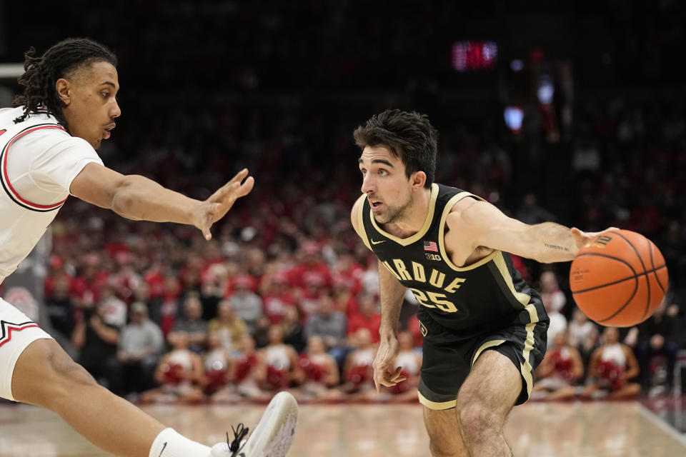 Purdue guard Ethan Morton (25) attempts to pass around Ohio State forward Devin Royal, left, in the first half of an NCAA college basketball game, Sunday, Feb. 18, 2024, in Columbus, Ohio. (AP Photo/Sue Ogrocki)