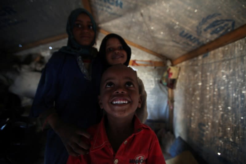 Children are pictured inside their hut at a camp for internally displaced people in Khamir of the northwestern province of Amran