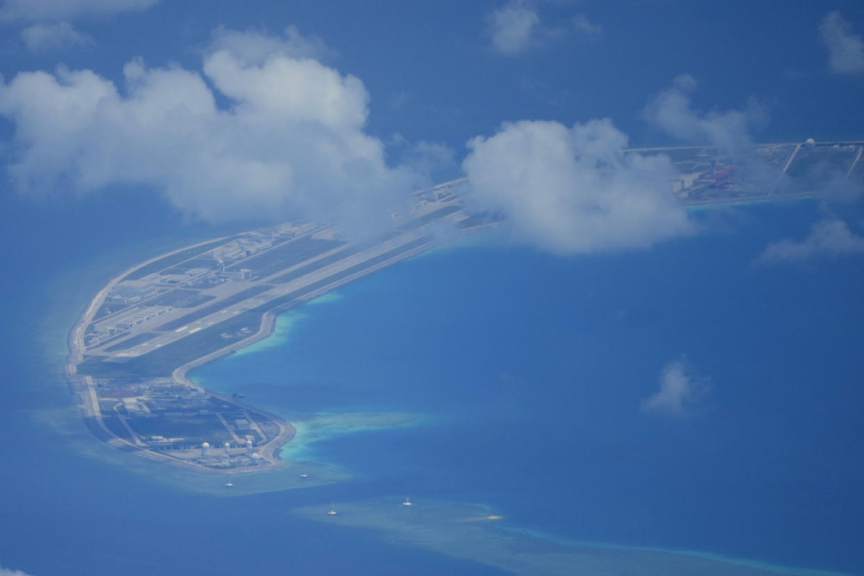 A Chinese air strip lies beside structures and buildings at the man-made island on Mischief Reef at the Spratly group of islands in the South China Sea are seen on Sunday March 20, 2022. China has fully militarized at least three of several islands it built in the disputed South China Sea, arming them with anti-ship and anti-aircraft missile systems, laser and jamming equipment and fighter jets in an increasingly aggressive move that threatens all nations operating nearby, a top U.S. military commander said Sunday. (AP Photo/Aaron Favila)