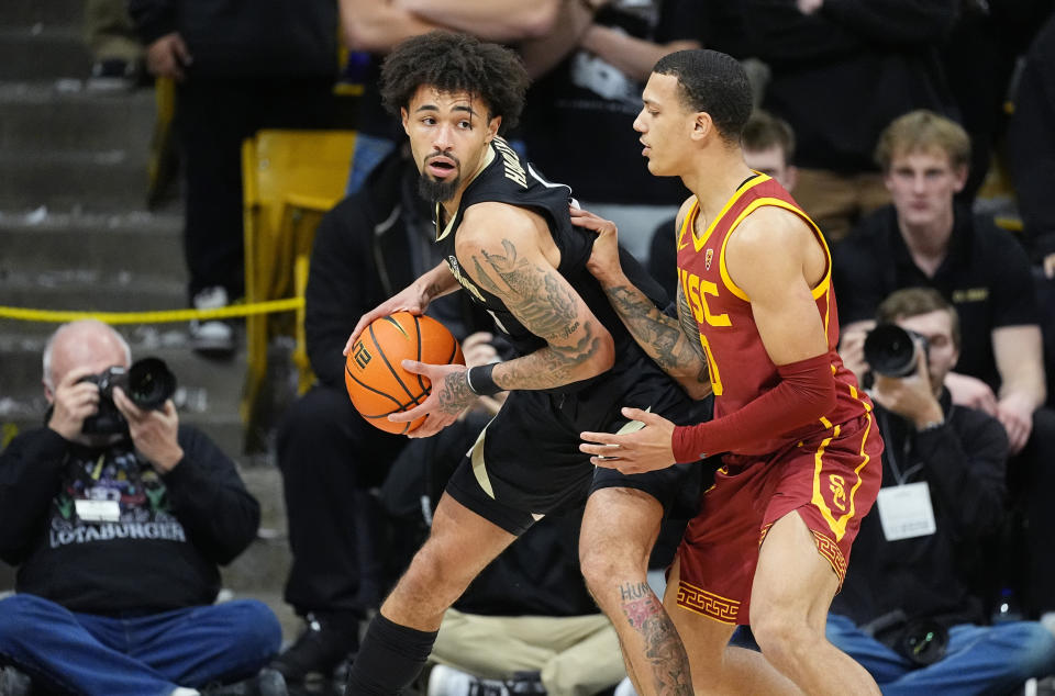 Colorado guard J'Vonne Hadley, left, looks to pass the ball as Southern California guard Kobe Johnson, right, defends in the first half of an NCAA college basketball game Saturday, Jan. 13, 2024, in Boulder, Colo. (AP Photo/David Zalubowski)