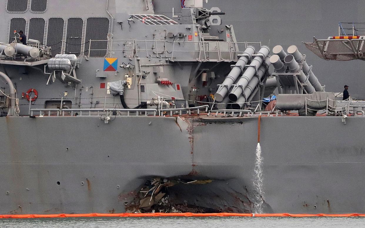 The damaged port aft hull of USS John S. McCain, is seen while docked at Singapore's Changi naval base on Tuesday - AP