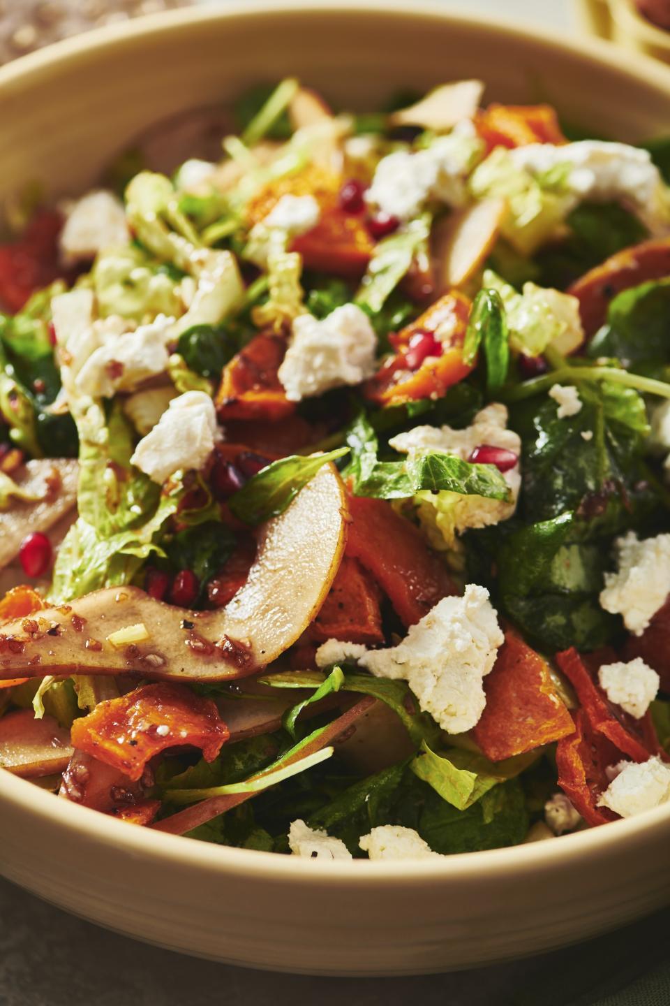 This image provided by Cheyenne Cohen shows a green salad with pears, pomegranate seeds, roasted butternut squash and vegan feta cheese. Many a Thanksgiving gathering these days will include meat eaters, vegetarians and vegans around the same table. AP food writer Katie Workman has practice creating one feast that can please all of them without a lot of extra work. (Cheyenne Cohen via AP)